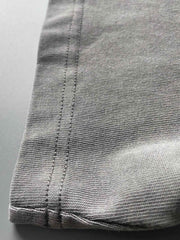 リブ付きクルーネックと精巧なブランド刺繍ロゴを備えたガーメントダイ仕上げビンテージウォッシュコットンTシャツのディテール。