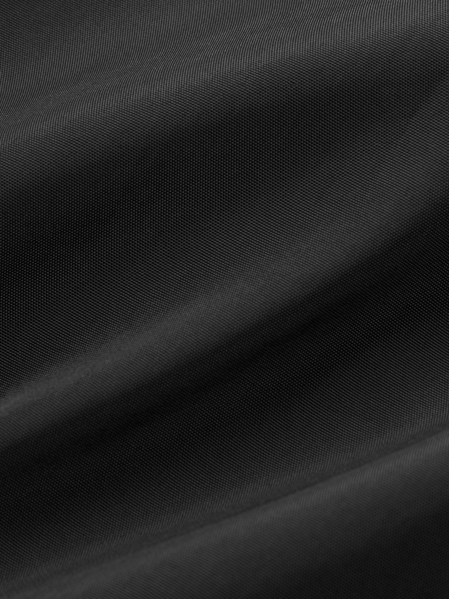 タクティカルベストの多機能ポケットのクローズアップ、精巧なデザインと軽量素材を強調。