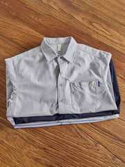 製品画像: オックスフォードカジュアルシャツの全体展示 詳細画像: シャツの肩部分の刺繍ディテールとプリーツデザイン