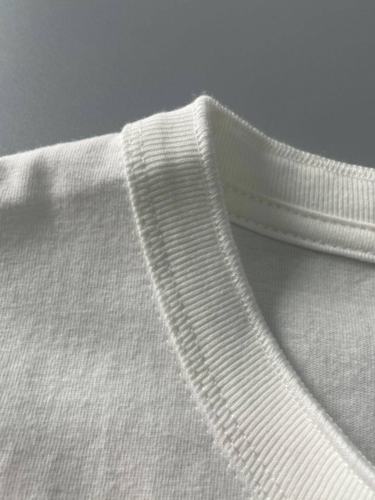 製品画像: クラシックヘンリーネックTシャツのフロント展示 詳細画像: リブネックと縫製ディテールの展示