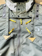 製品画像:57飛行隊機能性MA-1フライトジャケットの正面展示。取り外し可能なフード付きのミリタリー風ジャケット。
詳細画像:取り外し可能なフードと多機能ポケットのディテール。収納力と実用性を兼ね備えたデザイン。