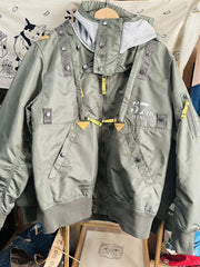 製品画像:57飛行隊機能性MA-1フライトジャケットの正面展示。取り外し可能なフード付きのミリタリー風ジャケット。
詳細画像:取り外し可能なフードと多機能ポケットのディテール。収納力と実用性を兼ね備えたデザイン。