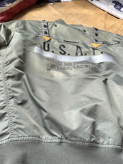 製品画像:57飛行隊機能性MA-1フライトジャケットの正面展示。取り外し可能なフード付きのミリタリー風ジャケット。
詳細画像:取り外し可能なフードと多機能ポケットのディテール。収納力と実用性を兼ね備えたデザイン。