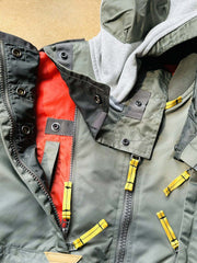 製品画像:57飛行隊機能性MA-1フライトジャケットの正面展示。取り外し可能なフード付きのミリタリー風ジャケット。
詳細画像:取り外し可能なフードと多機能ポケットのディテール。収納力と実用性を兼ね備えたデザイン。