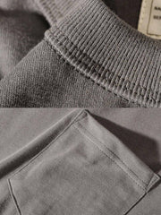 ポケット付きTシャツのクローズアップ。精巧なリブ編みネックラインとトリプルステッチが細部へのこだわりを示し、着心地と耐久性を強調しています。