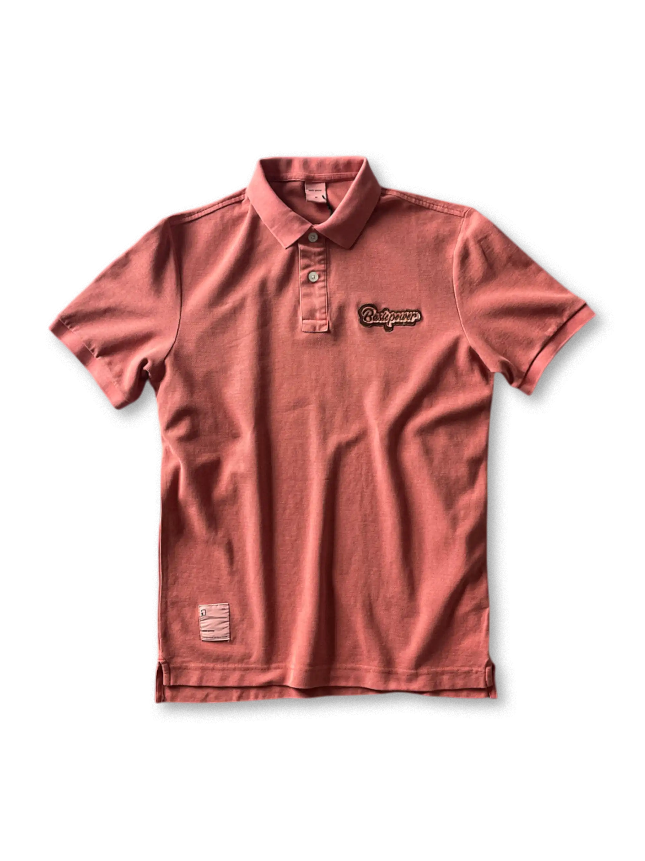 ヴィンテージウォッシュが施されたポロシャツ、胸元の刺繍ロゴが見える