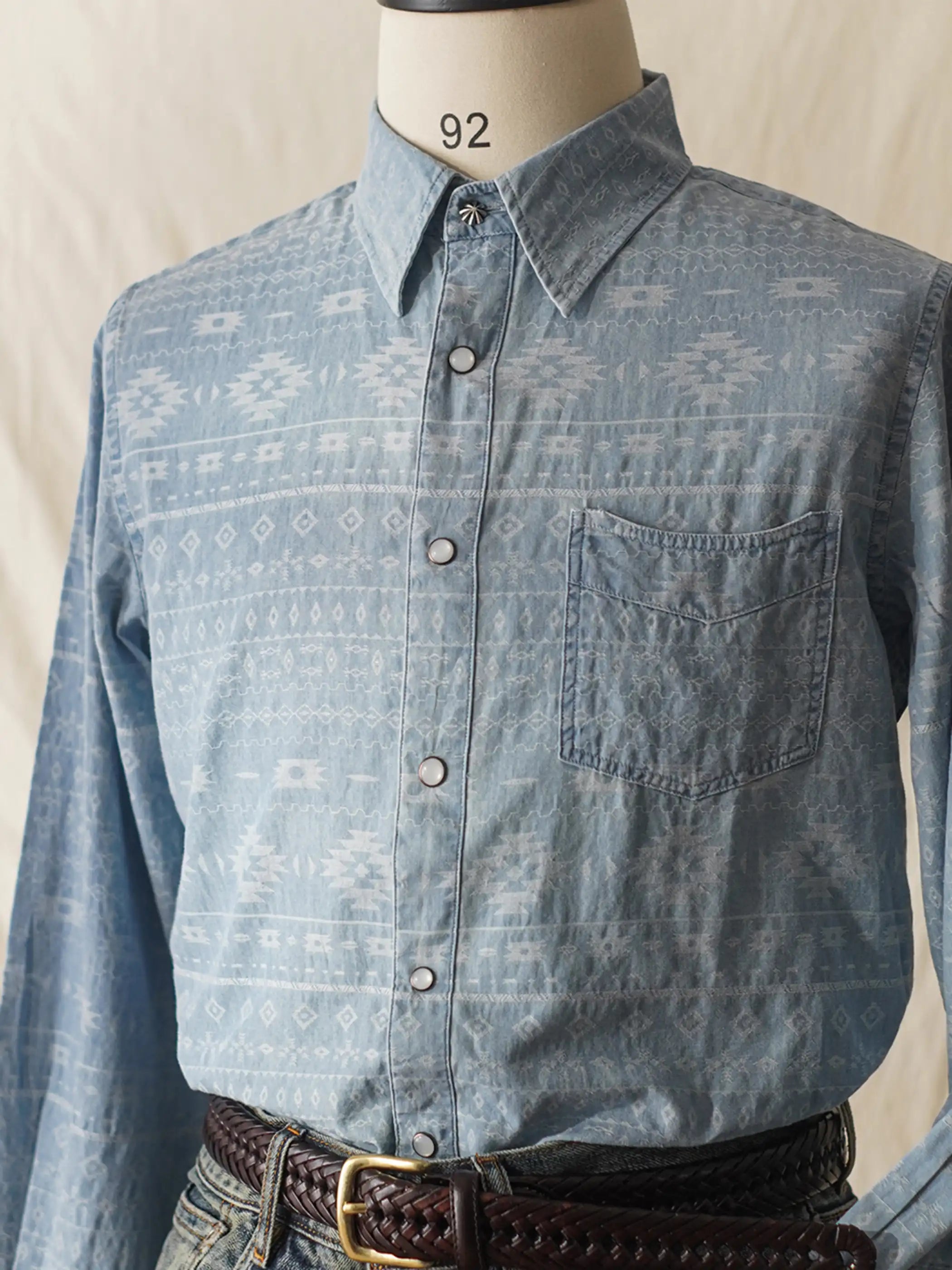 ジャカード織りのナバホ模様が施されたデニムシャツ、胸ポケットが特徴的