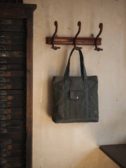 オリーブグリーン24オンスキャンバスのTalonジップ付きヴィンテージトートバッグ、前面フラップポケットと長めの肩紐の詳細。