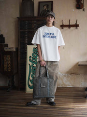 オリーブグリーン24オンスキャンバスのTalonジップ付きヴィンテージトートバッグ、前面フラップポケットと長めの肩紐の詳細。