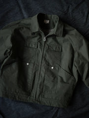 1930’sモーターサイクルジャケット、オリーブグリーンのSandstone Duck生地と多ポケットデザイン。詳細画像:YKK定製ボタン、酵素洗い加工のシワと色落ち、裏地の毛毡格子ディテール。モデル画像:モデルがジャケットを着用し、カジュアルなミリタリースタイルを演出。