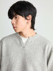 モデル画像:モデルがVネックセーターを着用し、カジュアルスタイルを披