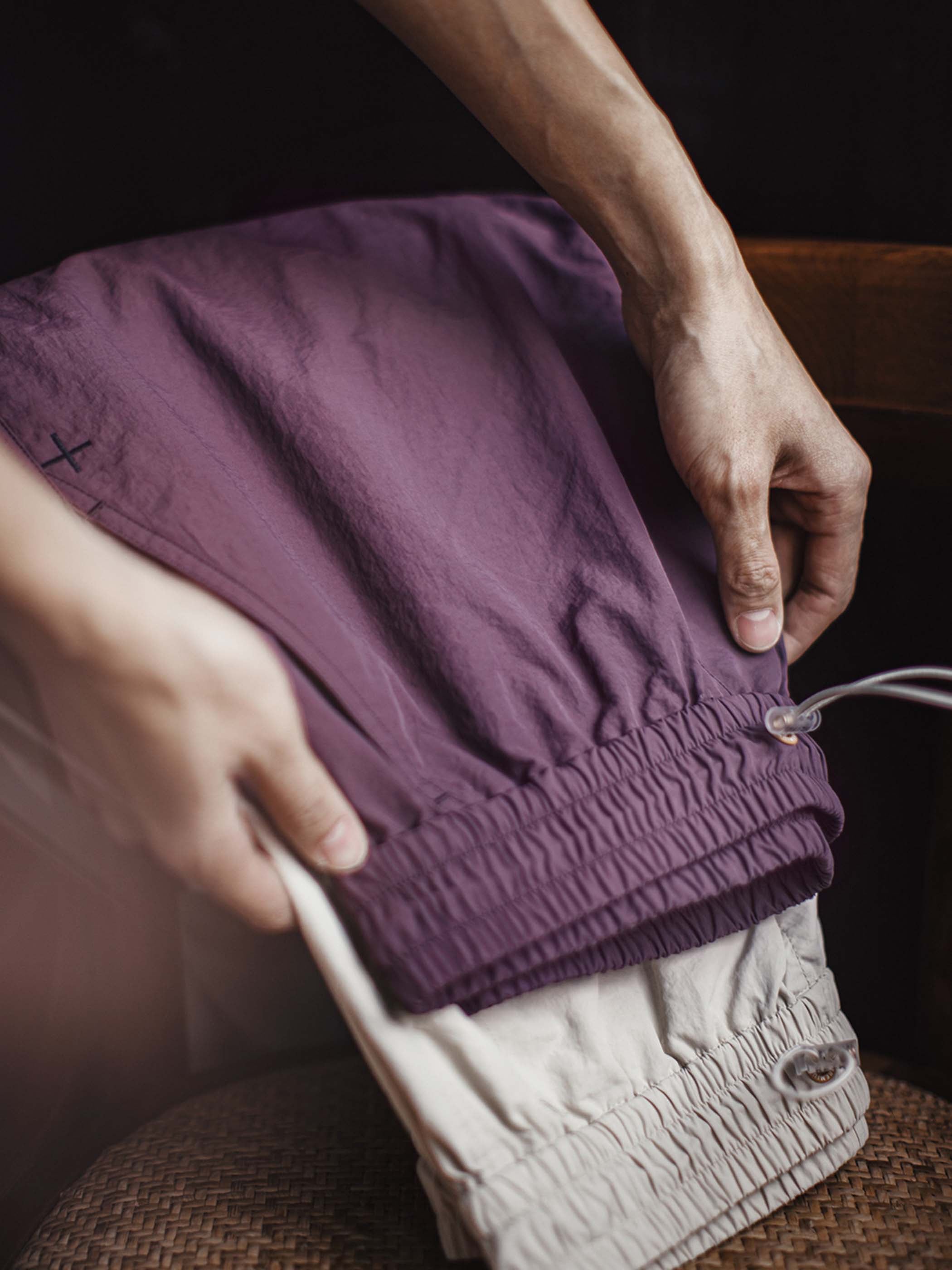 詳細画像: 膝のタックデザインと裾ドローコードのディテール特写