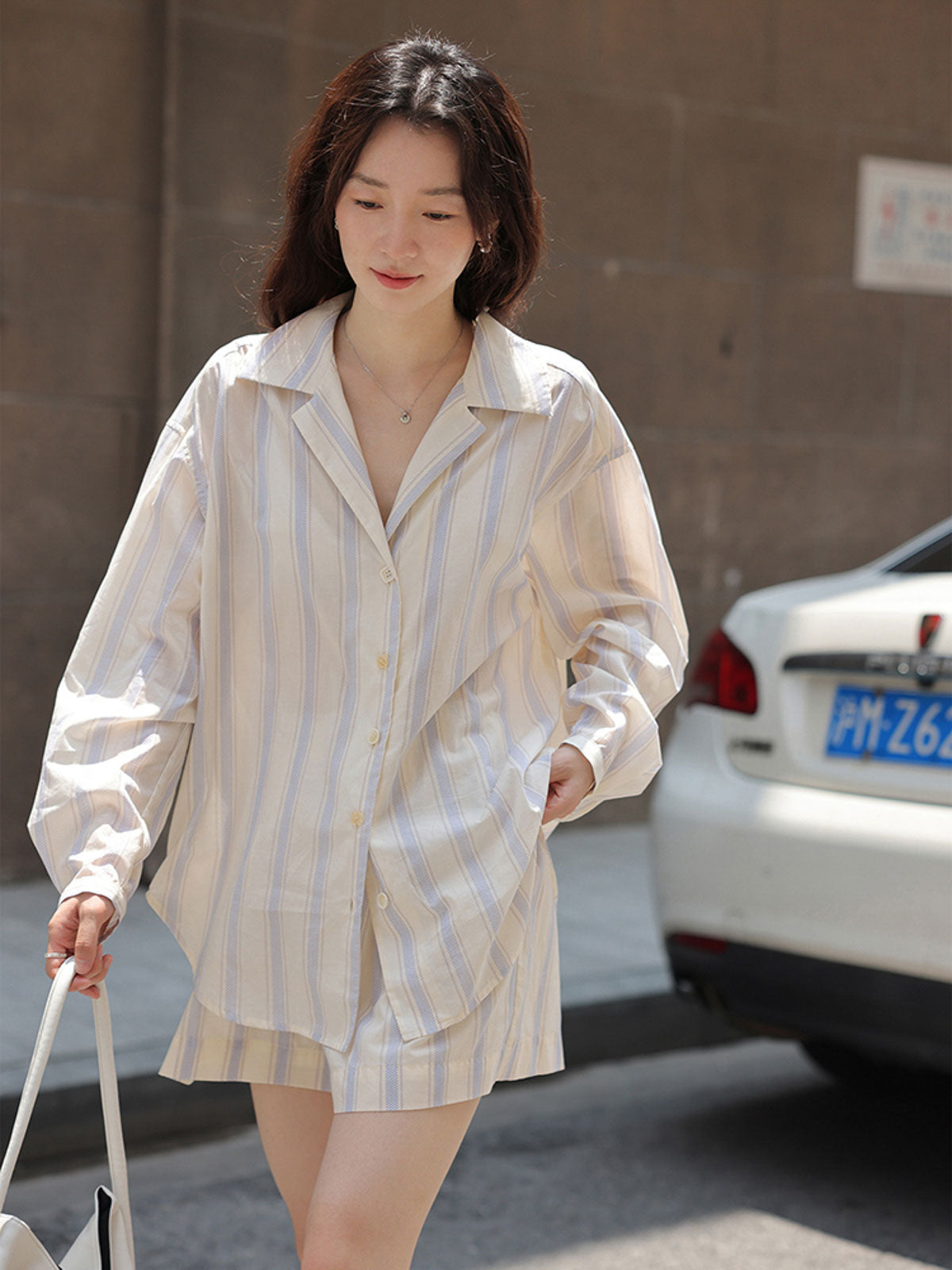 詳細画像: ストライプセットアップの詳細図。ピークドラペルデザインとワイドレッグショートパンツのゴムウエストデザインを展示。