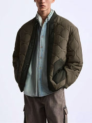 詳細画像
「パッチワーク テックファブリック 中綿ジャケットのフラップポケットと高品質ファスナーのディテール。耐久性と実用性を融合したデザイン」
モデル画像
「モデル着用のパッチワーク テックファブリック 中綿ジャケット。異素材のパッチワークとルーズフィットシルエットでレトロなワークスタイルを披露」