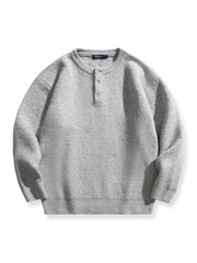 製品画像: 5色展開 ヘンリーネック ニットセーター。クラシックなヘンリーネックデザインと柔らかい混紡素材が特徴のセーターの正面全体展示図。
詳細画像: エレガントなヘンリーネックデザインと、シンプルながらデザイン性の高いボタンディテールのクローズアップ。