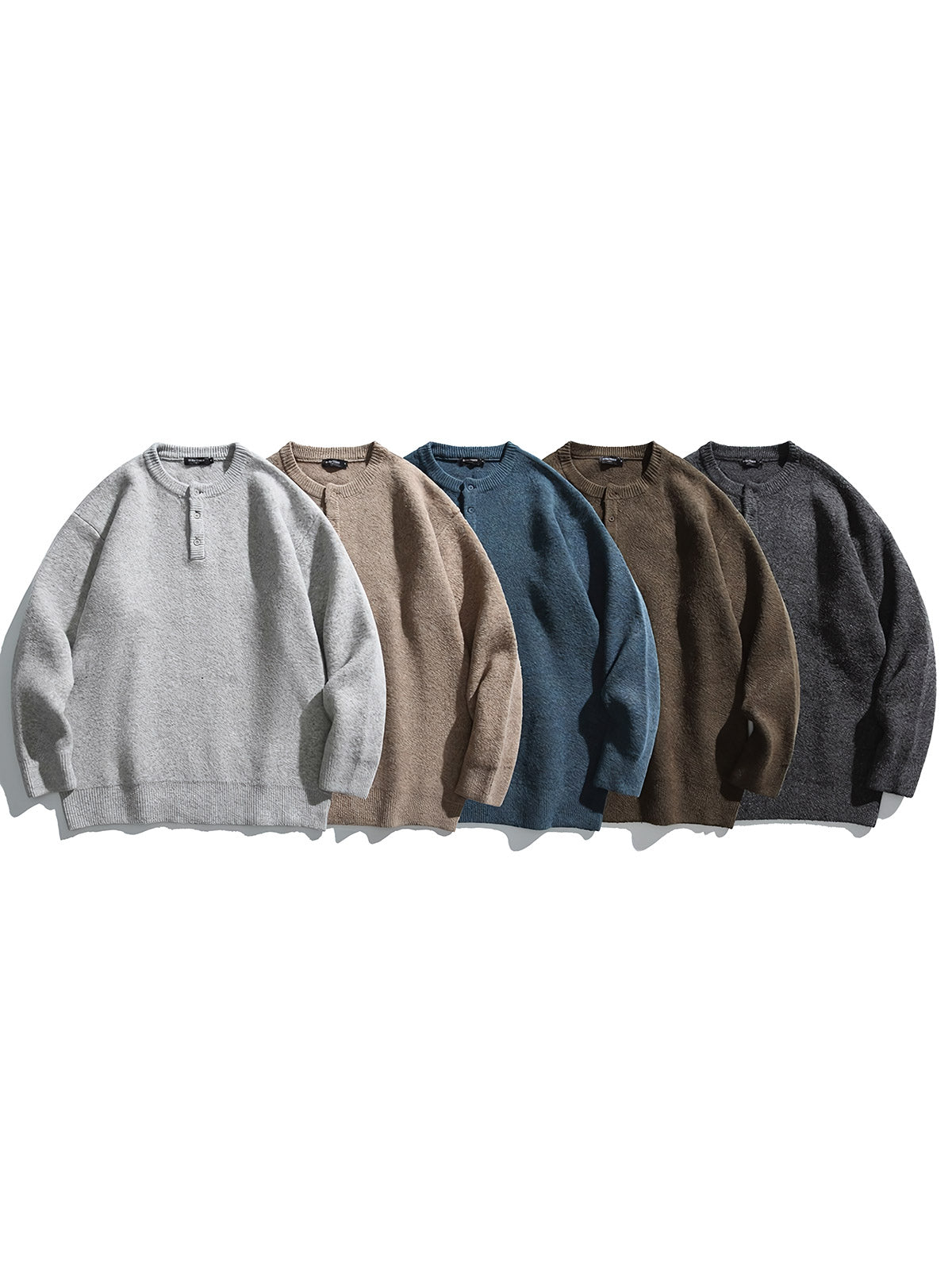 製品画像: 5色展開 ヘンリーネック ニットセーター。クラシックなヘンリーネックデザインと柔らかい混紡素材が特徴のセーターの正面全体展示図。
詳細画像: エレガントなヘンリーネックデザインと、シンプルながらデザイン性の高いボタンディテールのクローズアップ。