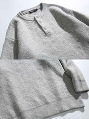 製品画像: 5色展開 ヘンリーネック ニットセーター。クラシックなヘンリーネックデザインと柔らかい混紡素材が特徴のセーターの正面全体展示図。
詳細画像: エレガントなヘンリーネックデザインと、シンプルながらデザイン性の高いボタンディテールのクローズアップ。