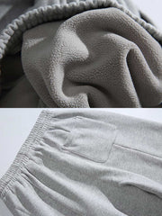 製品画像: 4色展開 カジュアル スウェットパンツ。裏起毛素材とルーズフィットデザインを採用した、冬に最適な厚手スウェットパンツの正面全体展示図。
詳細画像: 柔らかい裏起毛素材の質感と、冷気を防ぐ裾のリブデザインのディテールクローズアップ。