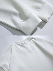 製品画像
「グレー・ホワイト・ブラックの3色展開クルーネック プルオーバースウェット全体像。ミニマルデザインとルーズフィットシルエットが特徴」
詳細画像
「クルーネック プルオーバースウェットの胸元シングルポケットとドロップショルダーデザインのディテールクローズアップ」