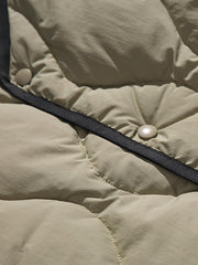 製品画像
「リバーシブル波形キルティングVネックダウン全体像。90%ホワイトダックダウン採用、カーキ、ブラック、アーミーグリーンの3色展開で実用性とスタイルを両立」
詳細画像
「リバーシブル波形キルティングダウンのポケットとキルティング加工のディテールクローズアップ。羽毛が均一に分布する設計」