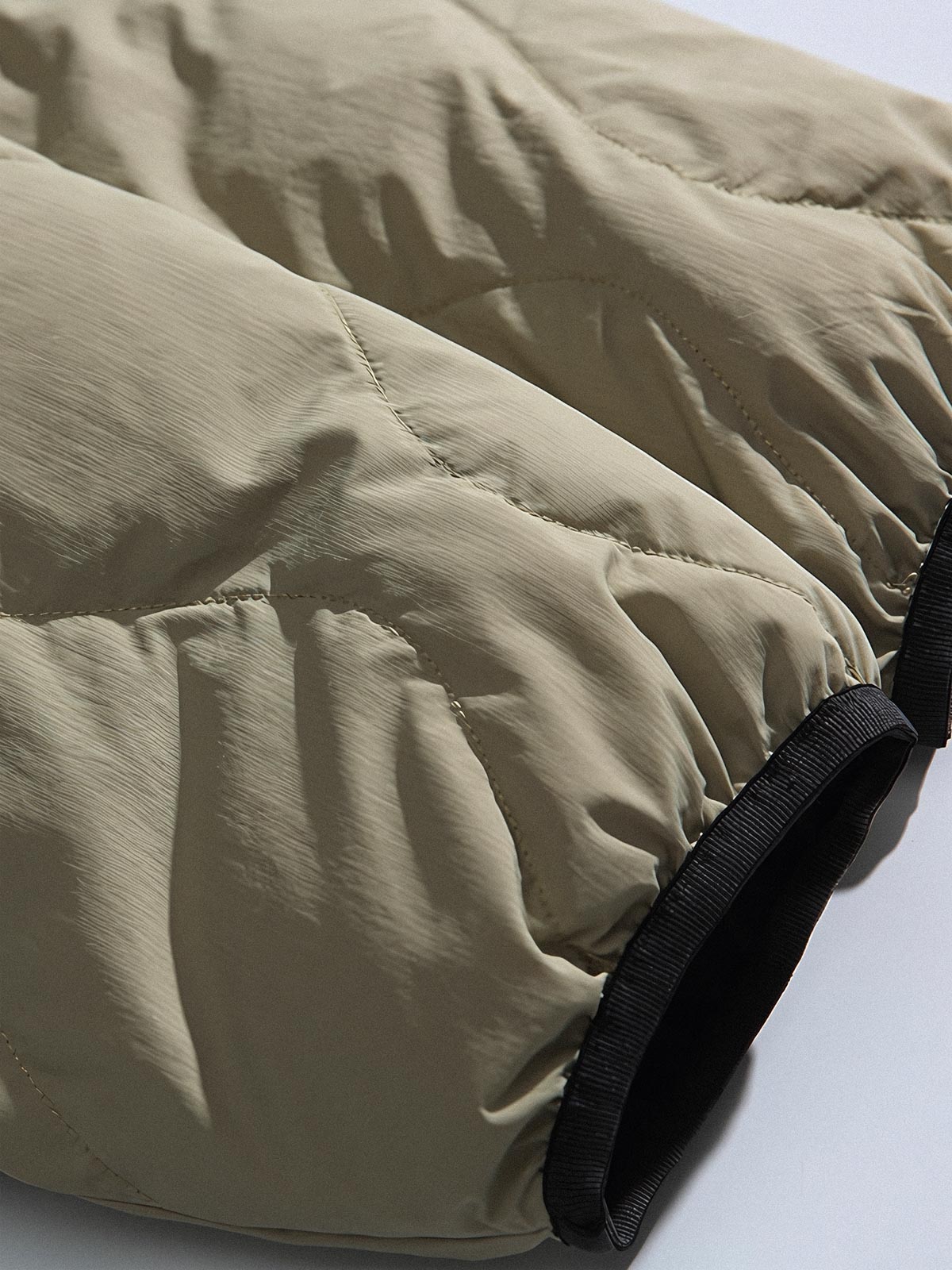 製品画像
「リバーシブル波形キルティングVネックダウン全体像。90%ホワイトダックダウン採用、カーキ、ブラック、アーミーグリーンの3色展開で実用性とスタイルを両立」
詳細画像
「リバーシブル波形キルティングダウンのポケットとキルティング加工のディテールクローズアップ。羽毛が均一に分布する設計」