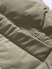 製品画像
「リバーシブル波形キルティングVネックダウン全体像。90%ホワイトダックダウン採用、カーキ、ブラック、アーミーグリーンの3色展開で実用性とスタイルを両立」
詳細画像
「リバーシブル波形キルティングダウンのポケットとキルティング加工のディテールクローズアップ。羽毛が均一に分布する設計」