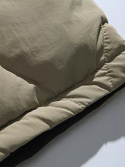 製品画像
「リバーシブル波形キルティングVネックダウン全体像。90%ホワイトダックダウン採用、カーキ、ブラック、アーミーグリーンの3色展開で実用性とスタイルを両立」
詳細画像
「リバーシブル波形キルティングダウンのポケットとキルティング加工のディテールクローズアップ。羽毛が均一に分布する設計」