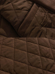 製品画像
「ブラックとコーヒーブラウンの2色展開ヘリンボーン柄中綿ロングコート全体像。クラシックなデザインと優れた保温性を備えた冬の必須アイテム」
詳細画像
「ヘリンボーン柄ロングコートのキルティング加工された内側とクラシックなボタンディテールのクローズアップ」