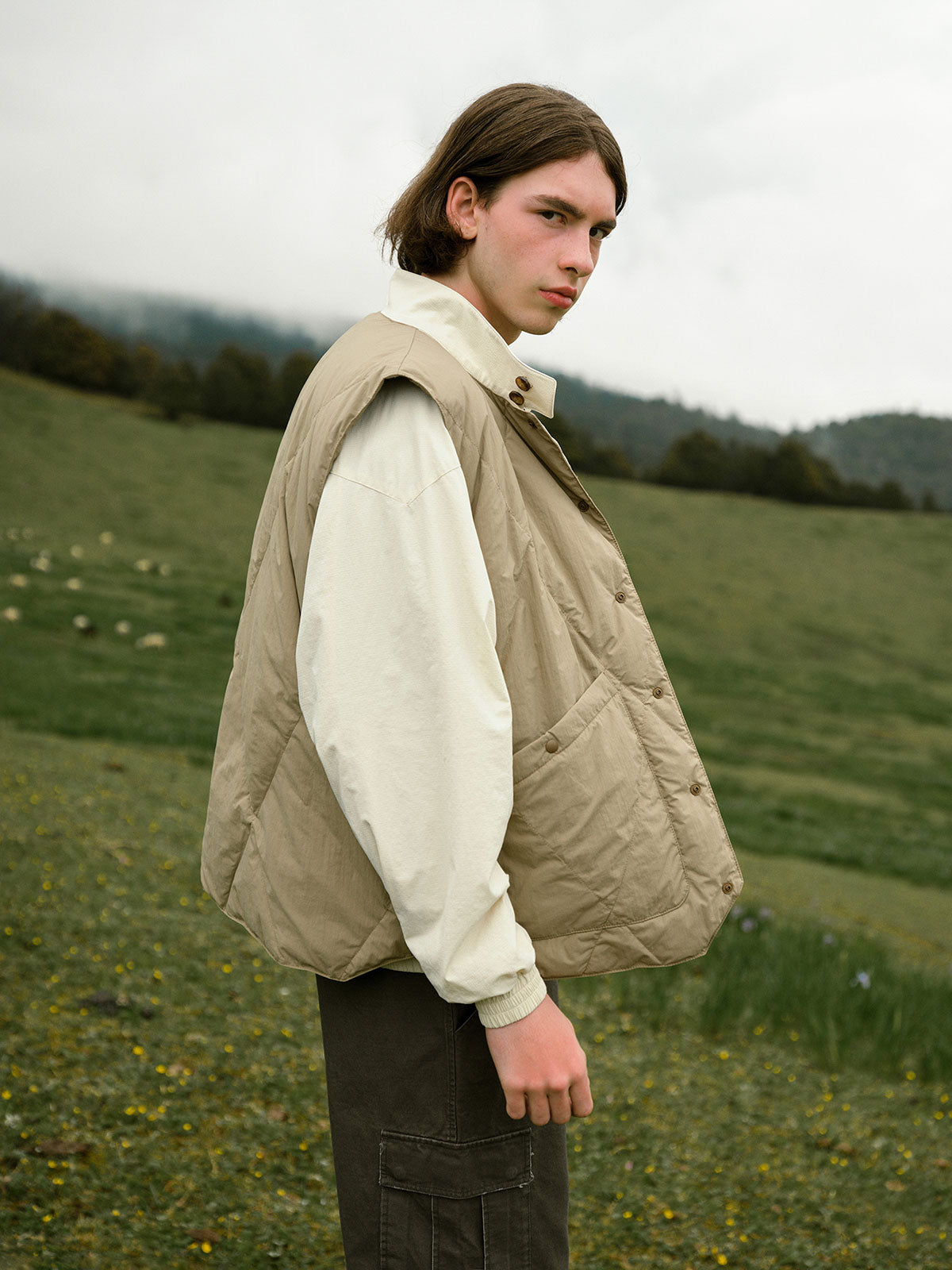 詳細画像: ダイヤキルティングデザインと撥水加工素材のディテール展示 - 冬のアウターに最適なスタイリッシュなデザイン。
モデル画像: モデル着用のレイヤードスタイルのダウンベスト - アウトドアやデイリーコーデにぴったりの万能アイテム。