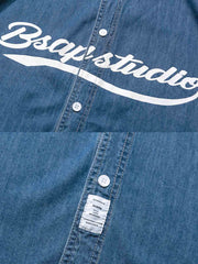 デニムベースボールシャツのブランドロゴのクローズアップ、白いプリントが施されたディテール。