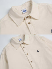 製品画像
ウォッシュ加工が施されたヴィンテージ感あふれるシャツ全体図。柔らかな生地の質感とココナッツ製ボタンの自然な風合いが際立つデザインで、ネイティブアメリカンのトーテム刺繍がアクセント
詳細画像
天然のココナッツ製ボタンと、背面に丁寧に施されたインディアンテントモチーフのトーテム刺繍のディテール。ウォッシュ加工による独特のヴィンテージ感と、18針/3cmの高密度縫製が美しい仕上がりを実現