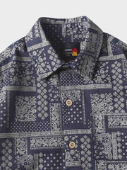 長袖シャツの民族風プリントのクローズアップ。幾何学的な形と自然要素の組み合わせが、古代文化への現代的な解釈と伝統への敬意を示しています。