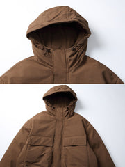 製品画像:
「立体ポケットとレイヤード風デザインを採用したフード付き中綿ジャケットの正面全体展示図。厚手生地と中綿裏地により抜群の保温性を提供し、ルーズフィットシルエットが防風性と快適さを両立。冬のアウトドアや通勤に最適な一着。」
詳細画像:
「フード付き中綿ジャケットのディテールクローズアップ。立体ポケットのデザインや、裾部分に施されたダブルレイヤーディテール、防風性能を高めるゴム仕様の袖口が特徴。」