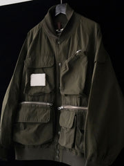 製品画像
「アシンメトリーデザインの多ポケットキャンプワークジャケット全体の展示図。クラシックなフィッシングジャケットとワークスタイルが融合したデザインで、ユニークなアシンメトリーデザインが実用性と個性を強調。防撥水機能を備えたポリエステルとコットン混紡生地を使用し、快適な着心地を提供します。」
詳細画像
「胸元のロゴ刺繍とアシンメトリーな多機能ポケットのディテール特写。YKKカスタムジッパーとロゴ入りスナップボタンが、高品質のディテールを引き立て、機能性とスタイルを両立させています。ダブルレイヤーのリブ編みが施され、袖口と裾のフィット感と耐久性を向上させています。」