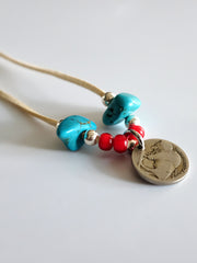 製品画像
「ハンドメイドインディアンコインネックレスの全体展示図。天然ターコイズ、アンティークガラスビーズ、アメリカの5セント硬貨を組み合わせたヴィンテージ感漂うデザインが特徴。」
詳細画像
「天然ターコイズとアンティークガラスビーズのディテール特写。各ビーズと硬貨が手作りで、個性あふれる美しさを際立たせています。」