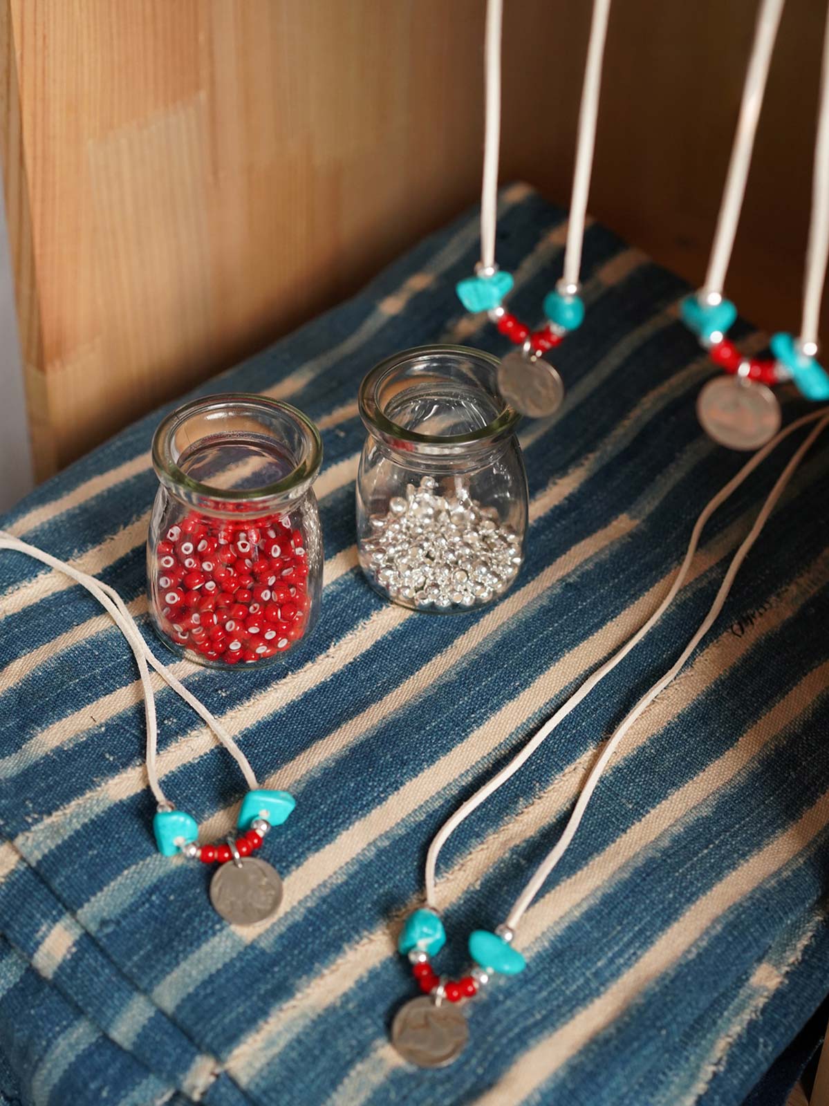 製品画像
「ハンドメイドインディアンコインネックレスの全体展示図。天然ターコイズ、アンティークガラスビーズ、アメリカの5セント硬貨を組み合わせたヴィンテージ感漂うデザインが特徴。」
詳細画像
「天然ターコイズとアンティークガラスビーズのディテール特写。各ビーズと硬貨が手作りで、個性あふれる美しさを際立たせています。」