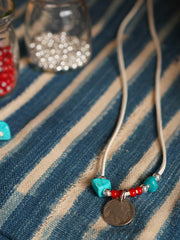 製品画像
「ハンドメイドインディアンコインネックレスの全体展示図。天然ターコイズ、アンティークガラスビーズ、アメリカの5セント硬貨を組み合わせたヴィンテージ感漂うデザインが特徴。」
詳細画像
「天然ターコイズとアンティークガラスビーズのディテール特写。各ビーズと硬貨が手作りで、個性あふれる美しさを際立たせています。」