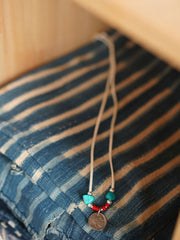 製品画像
「ハンドメイドインディアンコインネックレスの全体展示図。天然ターコイズ、アンティークガラスビーズ、アメリカの5セント硬貨を組み合わせたヴィンテージ感漂うデザインが特徴。」
詳細画像
「天然ターコイズとアンティークガラスビーズのディテール特写。各ビーズと硬貨が手作りで、個性あふれる美しさを際立たせています。」