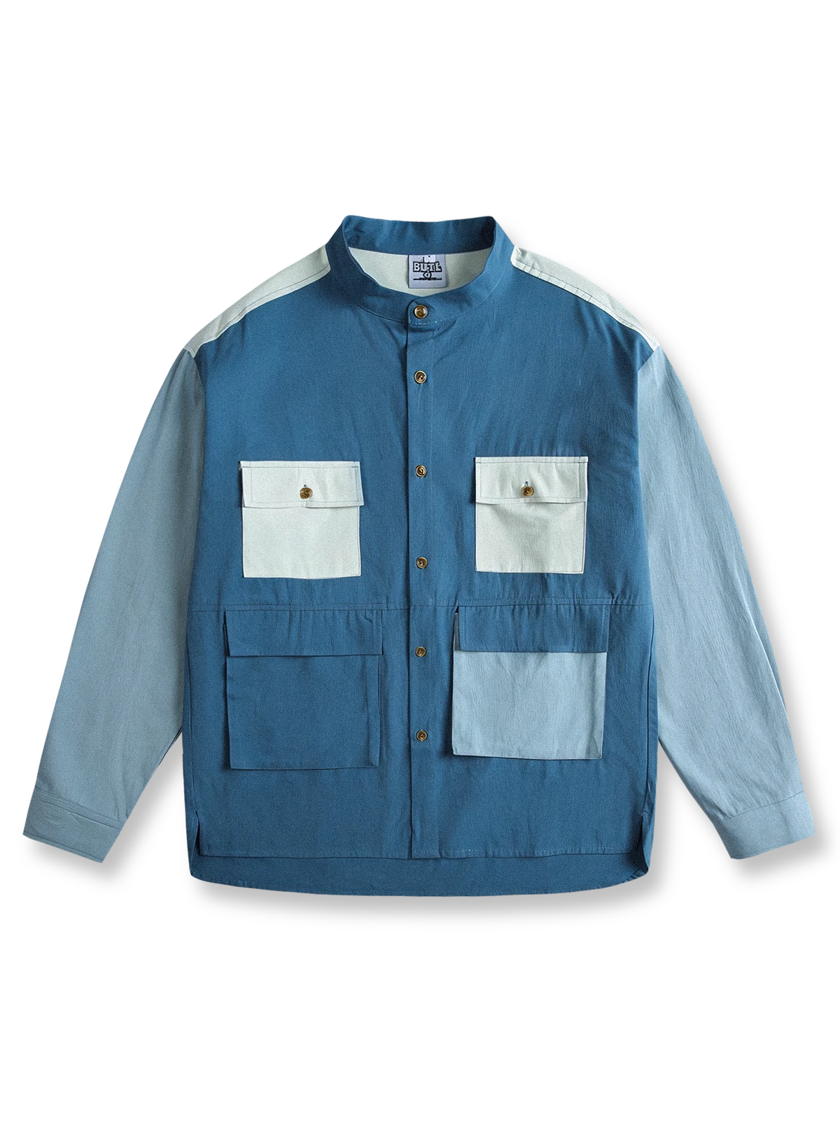 製品画像
カラーブロックデザインと小さなスタンドカラーが融合したワークシャツ、クラシックなワークウェアスタイルに現代的な感覚を加えたデザイン。柔らかく快適な素材で、1日中着用するのに適しています。
詳細画像
ユニークなカラーブロック要素と多ポケットデザインが特徴のワークシャツ。胸元の2つのカラーブロックポケットと裾の2つの大きなポケットが機能性とレイヤード感を引き立て、収納力も抜群です。小さなスタンドカラーがディテールにアクセントを加えています。