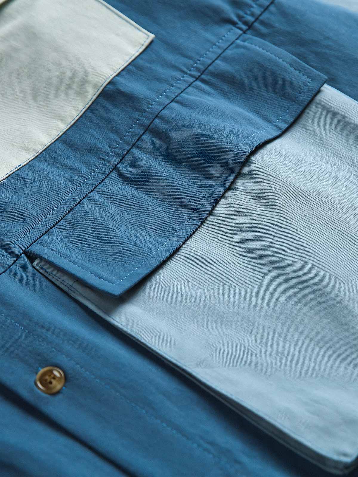 製品画像
カラーブロックデザインと小さなスタンドカラーが融合したワークシャツ、クラシックなワークウェアスタイルに現代的な感覚を加えたデザイン。柔らかく快適な素材で、1日中着用するのに適しています。
詳細画像
ユニークなカラーブロック要素と多ポケットデザインが特徴のワークシャツ。胸元の2つのカラーブロックポケットと裾の2つの大きなポケットが機能性とレイヤード感を引き立て、収納力も抜群です。小さなスタンドカラーがディテールにアクセントを加えています。