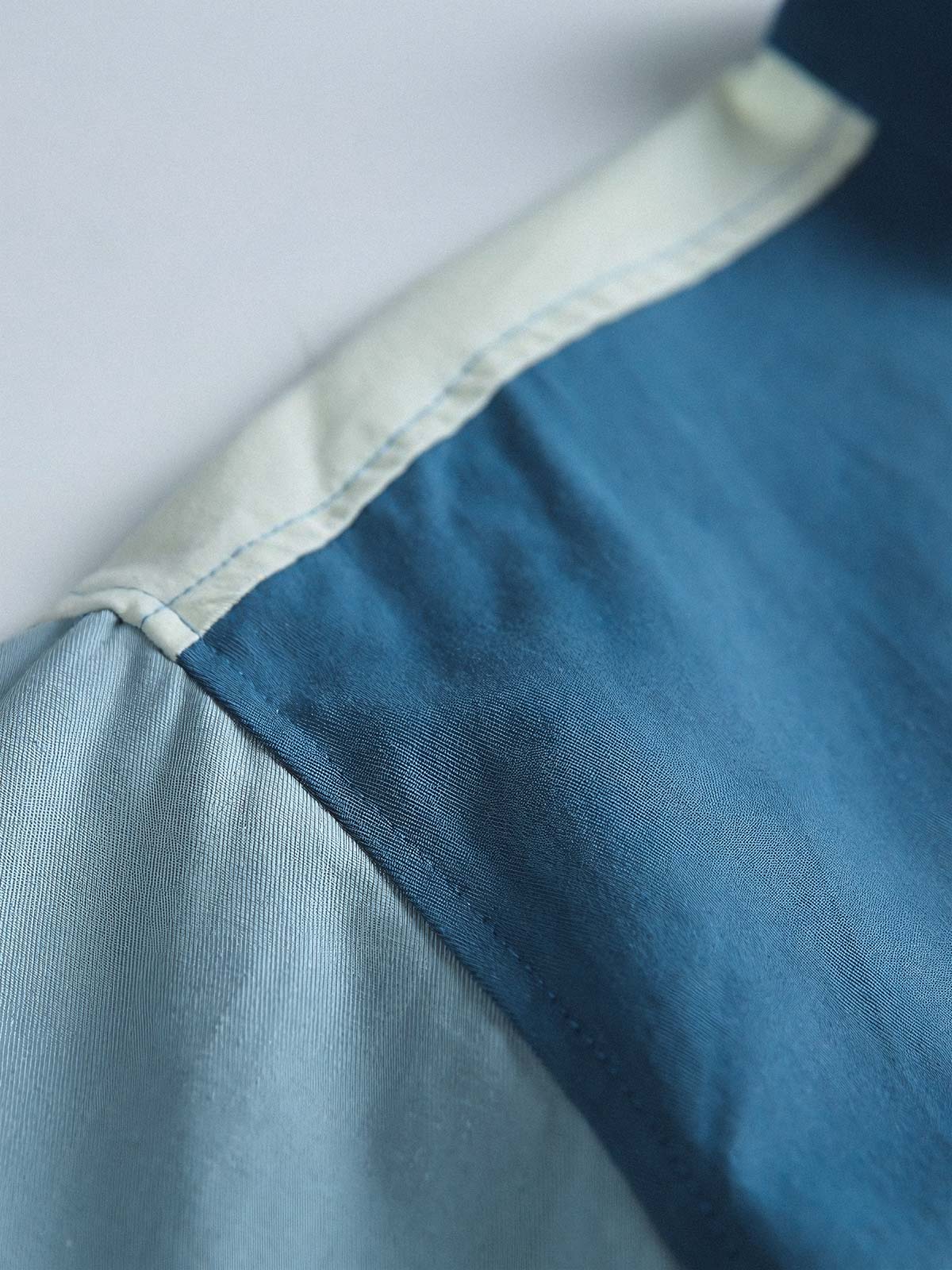 製品画像
カラーブロックデザインと小さなスタンドカラーが融合したワークシャツ、クラシックなワークウェアスタイルに現代的な感覚を加えたデザイン。柔らかく快適な素材で、1日中着用するのに適しています。
詳細画像
ユニークなカラーブロック要素と多ポケットデザインが特徴のワークシャツ。胸元の2つのカラーブロックポケットと裾の2つの大きなポケットが機能性とレイヤード感を引き立て、収納力も抜群です。小さなスタンドカラーがディテールにアクセントを加えています。