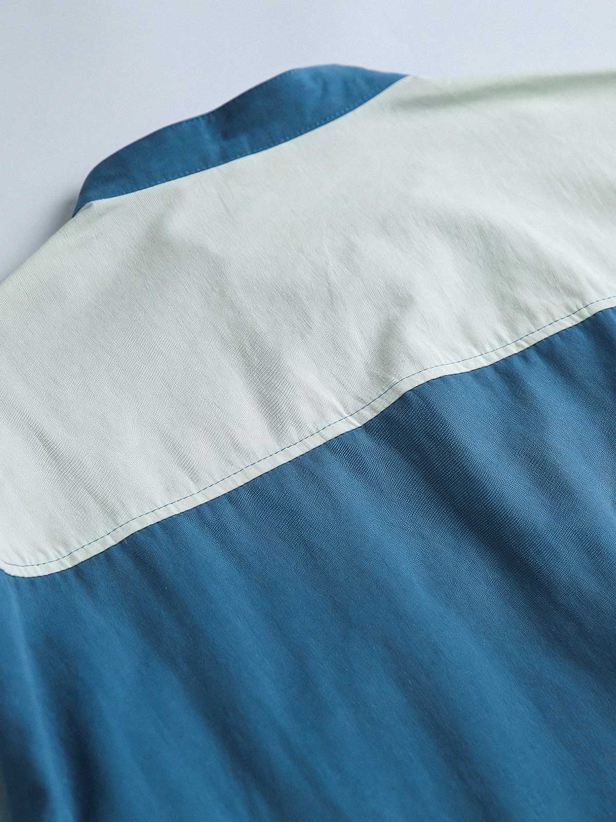 製品画像
カラーブロックデザインと小さなスタンドカラーが融合したワークシャツ、クラシックなワークウェアスタイルに現代的な感覚を加えたデザイン。柔らかく快適な素材で、1日中着用するのに適しています。
詳細画像
ユニークなカラーブロック要素と多ポケットデザインが特徴のワークシャツ。胸元の2つのカラーブロックポケットと裾の2つの大きなポケットが機能性とレイヤード感を引き立て、収納力も抜群です。小さなスタンドカラーがディテールにアクセントを加えています。