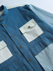 製品画像
カラーブロックデザインと小さなスタンドカラーが融合したワークシャツ、クラシックなワークウェアスタイルに現代的な感覚を加えたデザイン。柔らかく快適な素材で、1日中着用するのに適しています。
詳細画像
ユニークなカラーブロック要素と多ポケットデザインが特徴のワークシャツ。胸元の2つのカラーブロックポケットと裾の2つの大きなポケットが機能性とレイヤード感を引き立て、収納力も抜群です。小さなスタンドカラーがディテールにアクセントを加えています。