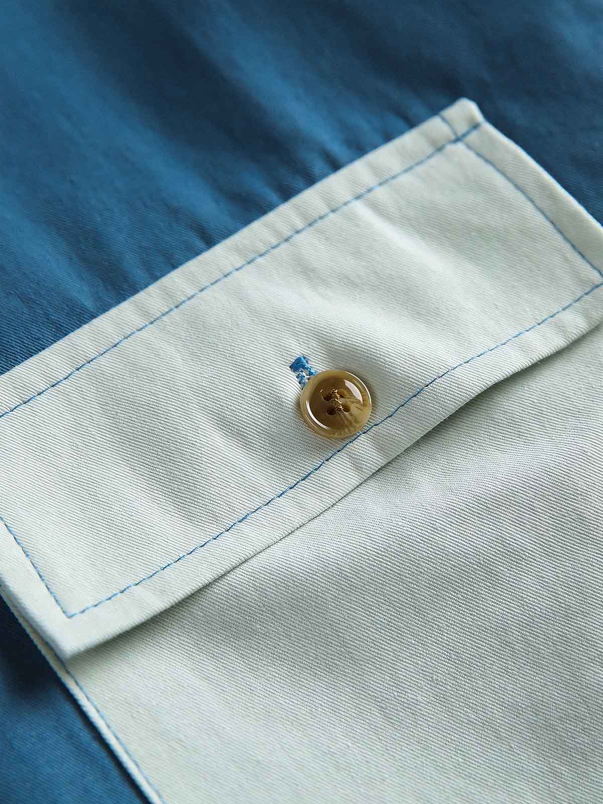 製品画像
カラーブロックデザインと小さなスタンドカラーが融合したワークシャツ、クラシックなワークウェアスタイルに現代的な感覚を加えたデザイン。柔らかく快適な素材で、1日中着用するのに適しています。
詳細画像
ユニークなカラーブロック要素と多ポケットデザインが特徴のワークシャツ。胸元の2つのカラーブロックポケットと裾の2つの大きなポケットが機能性とレイヤード感を引き立て、収納力も抜群です。小さなスタンドカラーがディテールにアクセントを加えています。