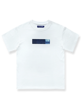 製品画像: 白色の半袖Tシャツの正面画像、胸元に幾何学パッチ付き