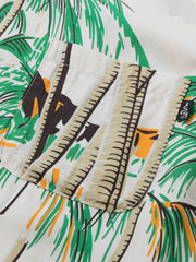 シャツのディテールショット、真珠ボタンと裾の余白デザインを示す。