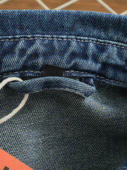 シャツのダブルポケットと金属ボタンのディテール画像。