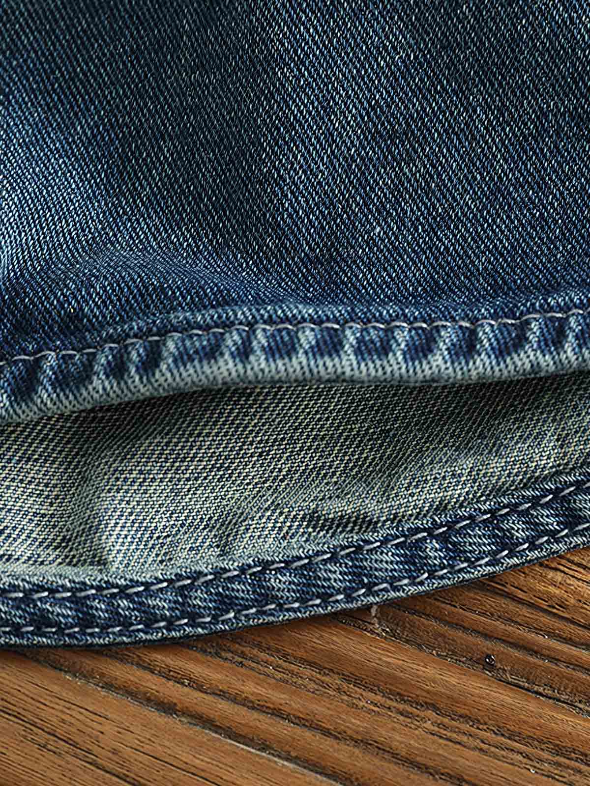 シャツのダブルポケットと金属ボタンのディテール画像。