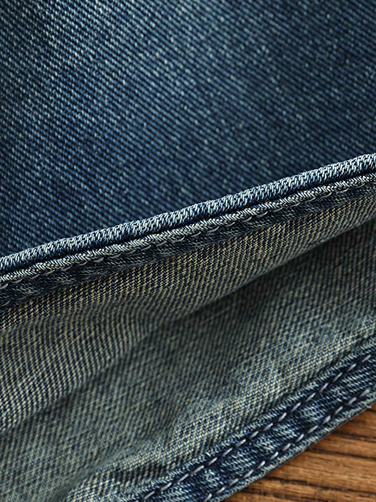 シャツのダブルポケットと金属ボタンのディテール画像。