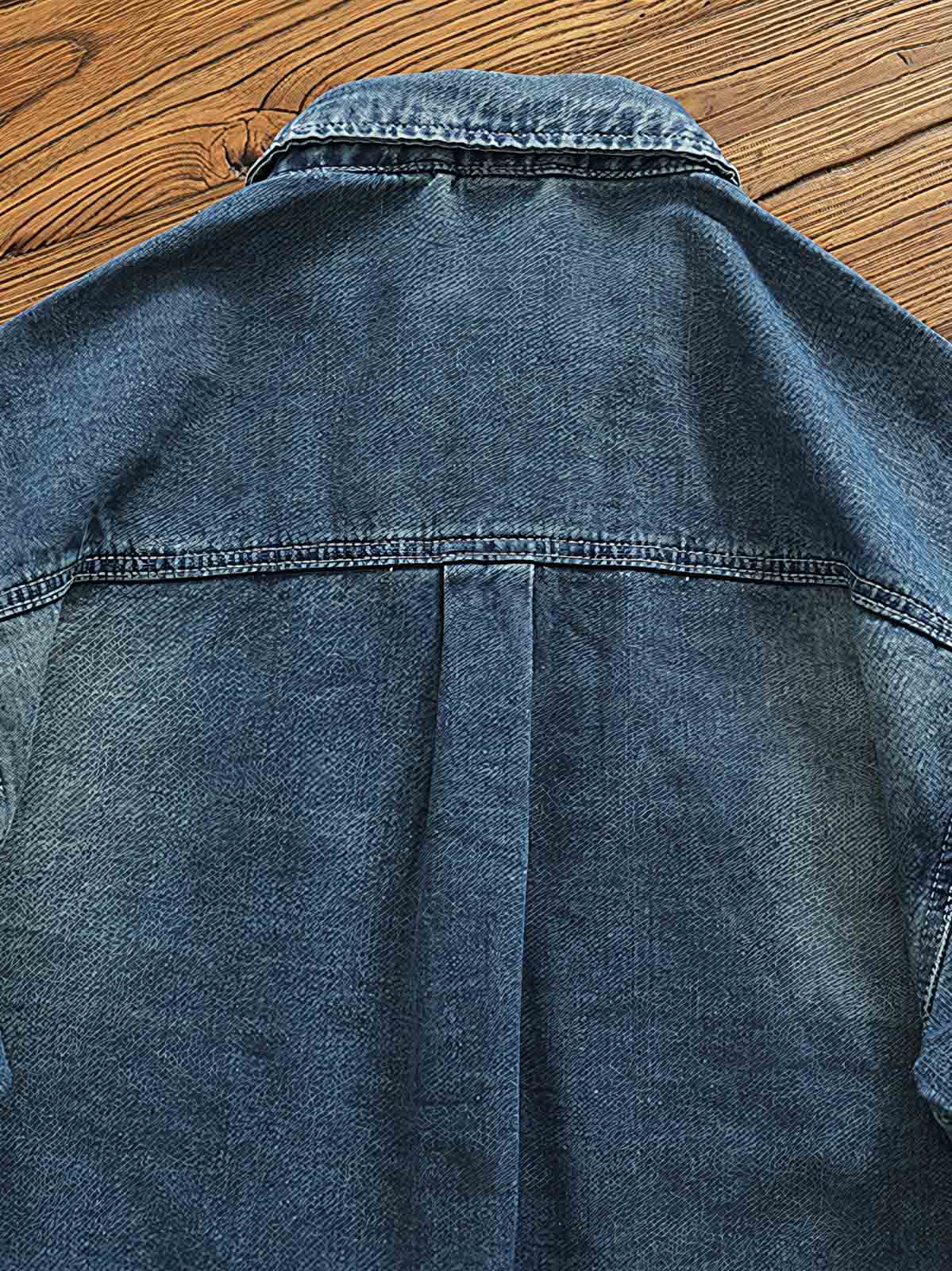 シャツのダブルポケットと金属ボタンのディテール画像。